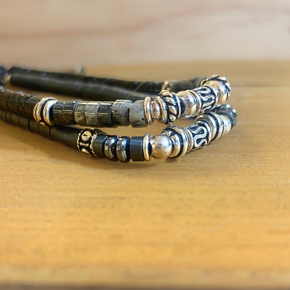 Bracelet Homme fait main en Hématite et Argent 925 posé sur un socle en boios avec un autre bracelet au dessus - Ancrage Byartmexbijoux