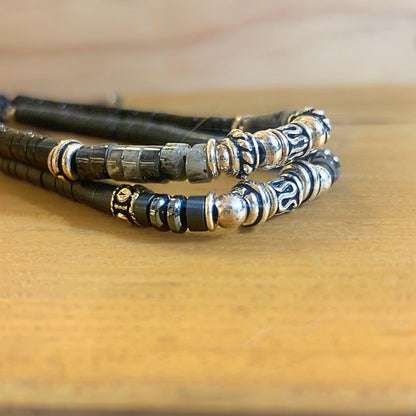 Bracelet Homme fait main en Hématite et Argent 925 posé sur un socle en boios avec un autre bracelet au dessus - Ancrage Byartmexbijoux