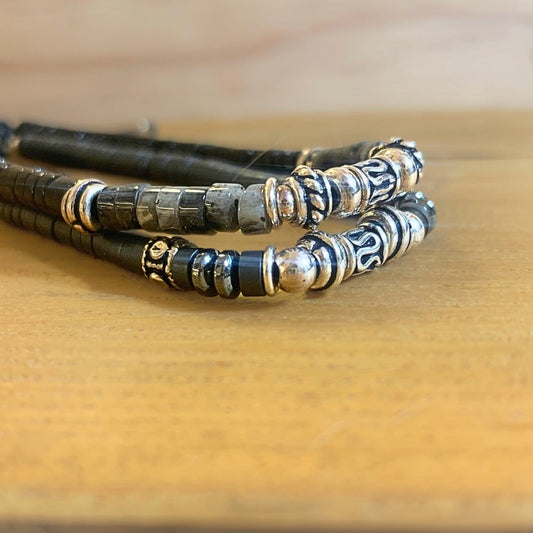 Bracelet Homme fait main en Hématite et Argent 925 posé sur un socle en boios avec un autre bracelet au dessus - Ancrage Byartmexbijoux