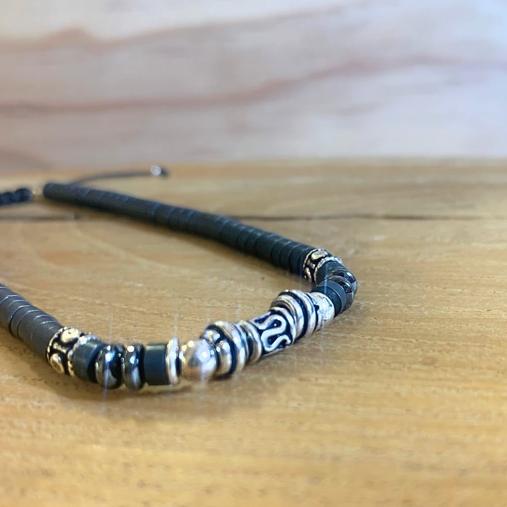 Gros plan Bracelet Heishi Hématite et Argent 925 posé sur socle en bois - Ancrage Byartmexbijoux
