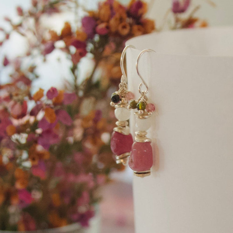 Paire de boucles d’oreilles créations en tourmaline rose e argent 9é( posées sur le rebord d’une tasse