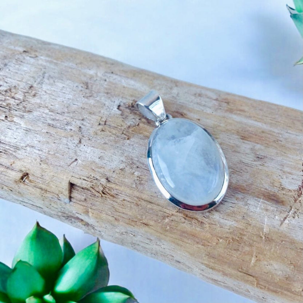 Pendentif Pierre de Lune posé sur un bois flotté