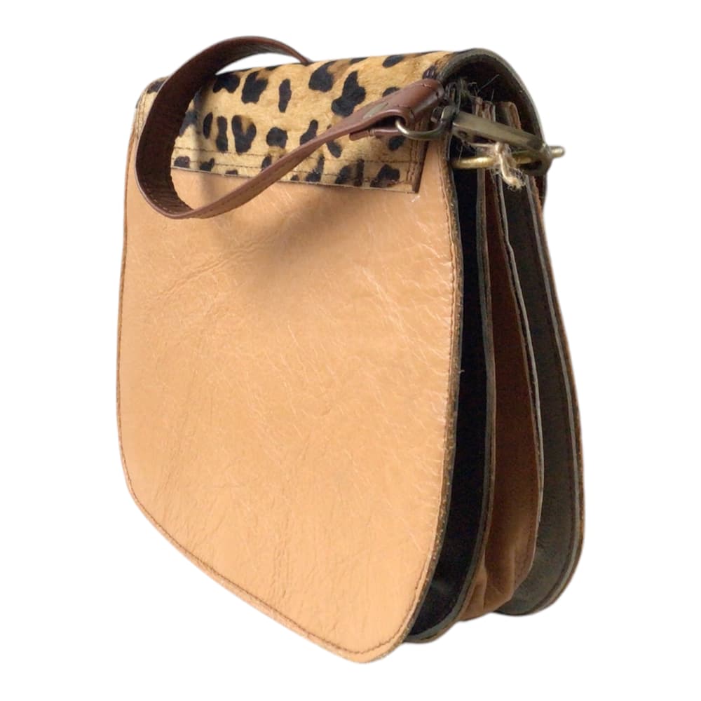 Vue arrière sur fond blanc d’un sac à main femme en forme de selle en cuir recyclé marron