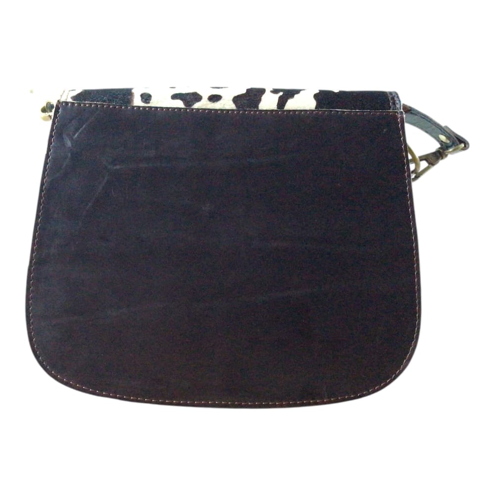 Vue de dos sur fond blanc d’un sac à main femme en forme de selle en cuir recyclé marron