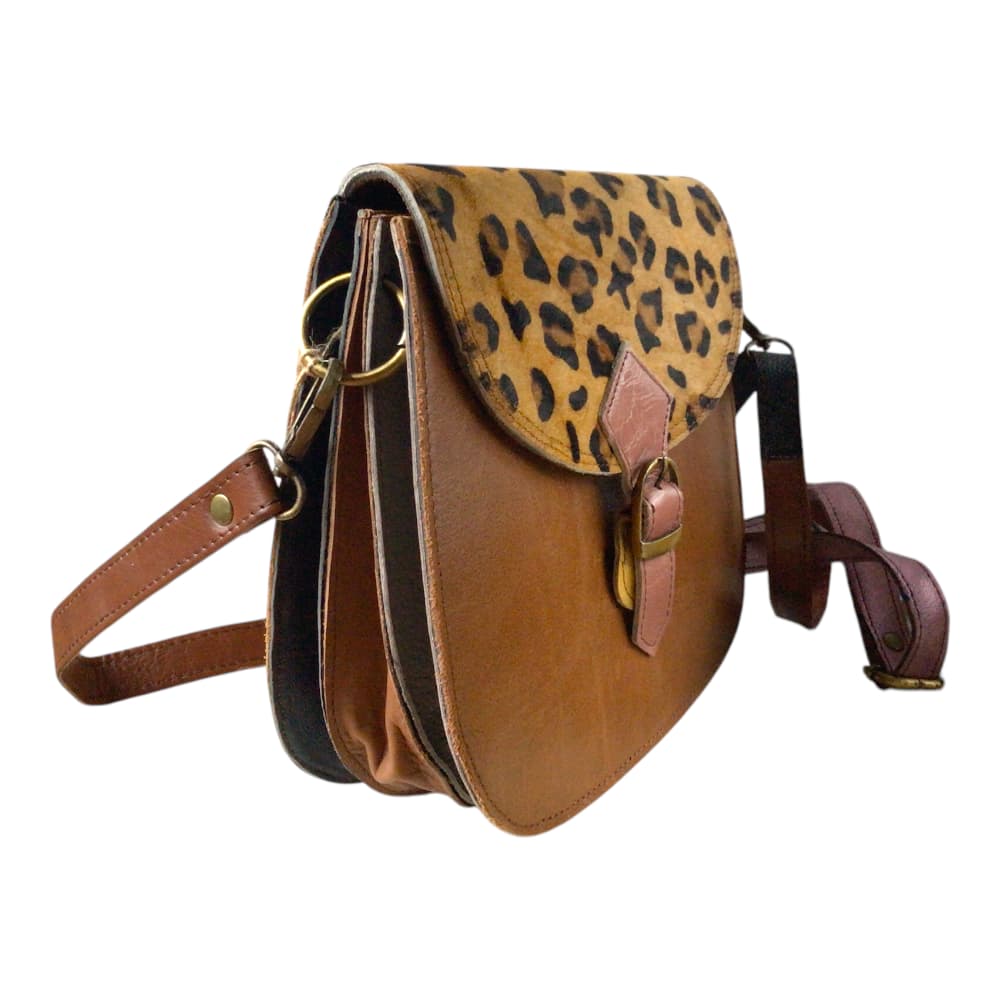 Vue de profil sur fond blanc d’un sac à main femme en forme de selle en cuir recyclé marron