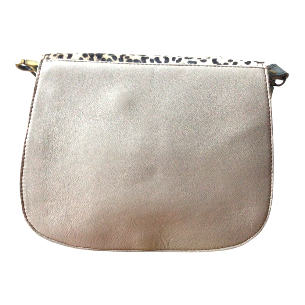Vue de dosl sur fond blanc d’un sac à main femme en forme de selle en cuir recyclé marron