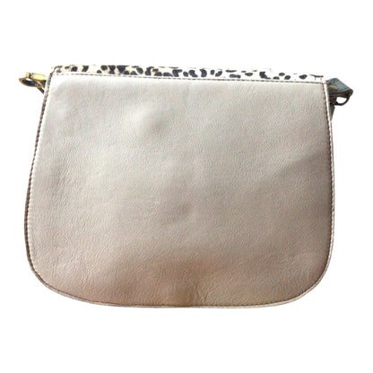Vue de dosl sur fond blanc d’un sac à main femme en forme de selle en cuir recyclé marron